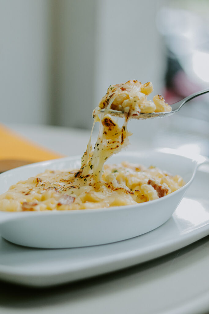 A bowl of creamy mac and cheese made with Tini’s best pasta choice, featuring perfectly cooked cavatappi pasta coated in velvety cheese sauce.