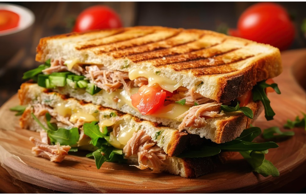 A hearty turkey and cheese sandwich layered with crisp lettuce, ripe tomato, and creamy cheese on whole-grain bread.