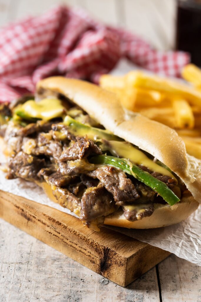 Close-up of a Philly cheesesteak with melted cheese, tender steak, and toasted bread, showcasing its secret ingredient.