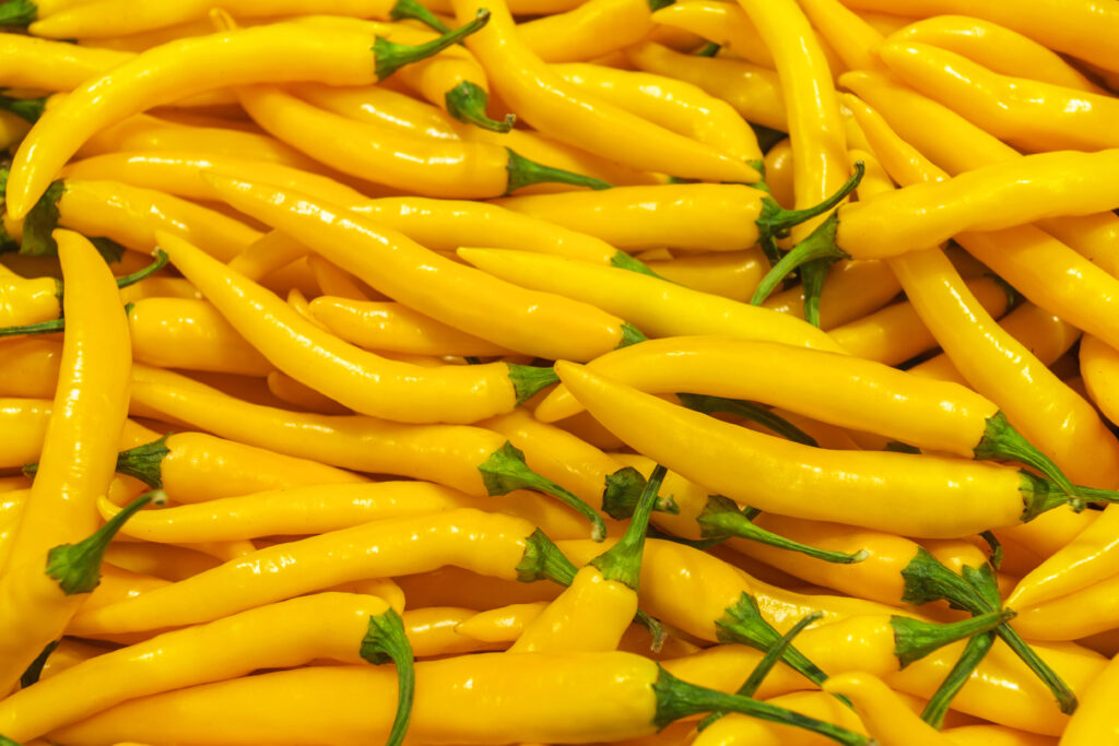 A close-up of fresh, bright yellow banana pepper with a smooth, waxy texture, perfect for cooking or pickling.
