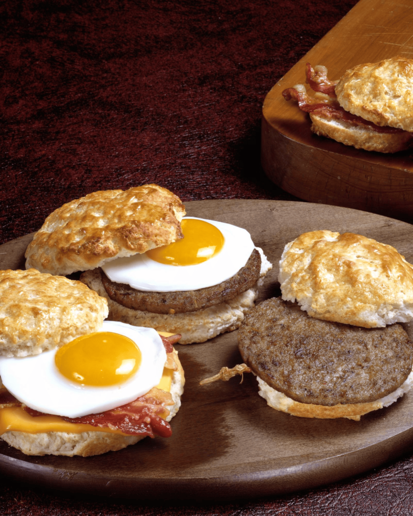 selection of Wendy’s breakfast menu items, including a Bacon, Egg & Cheese Croissant, seasoned potatoes, and a Frosty-ccino.